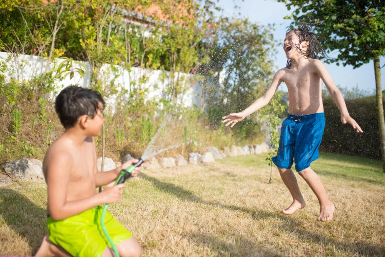 a  playing with a water sprinkler