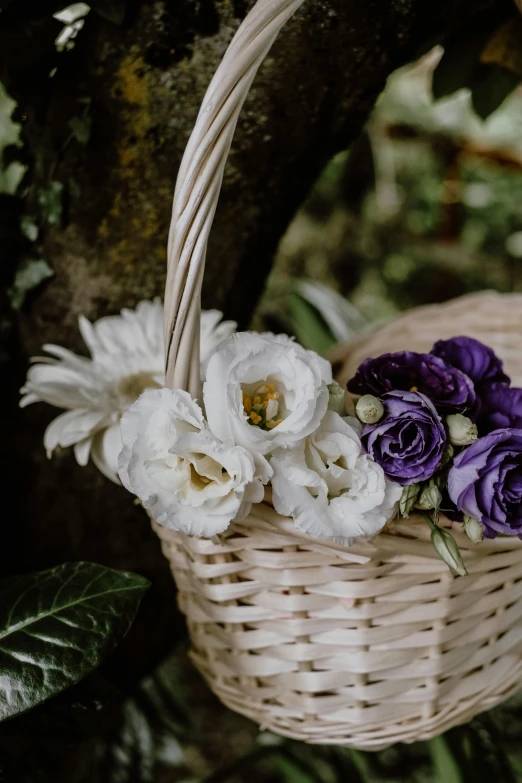 a basket filled with purple and white flowers