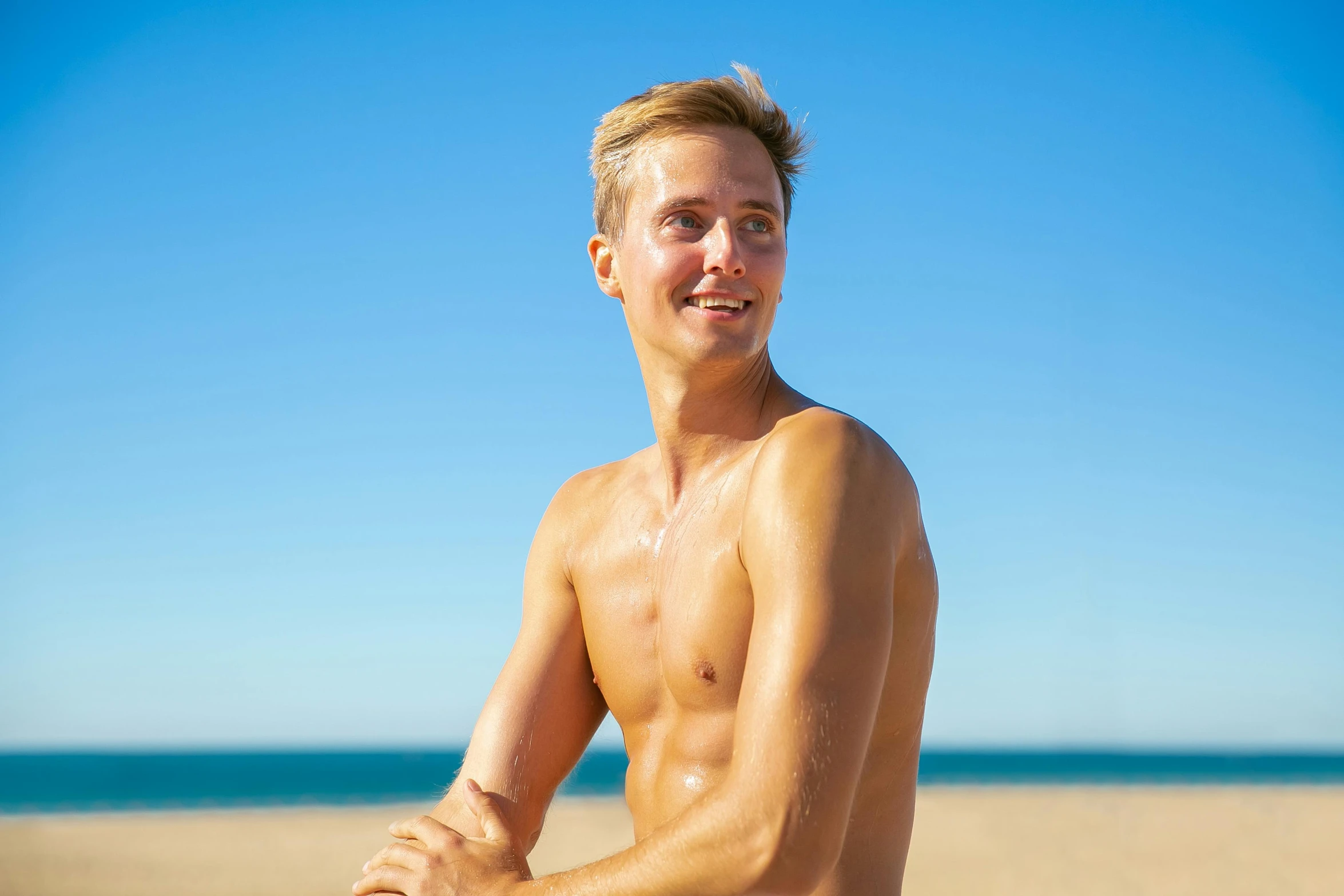 young man with  holding his surfboard on the beach