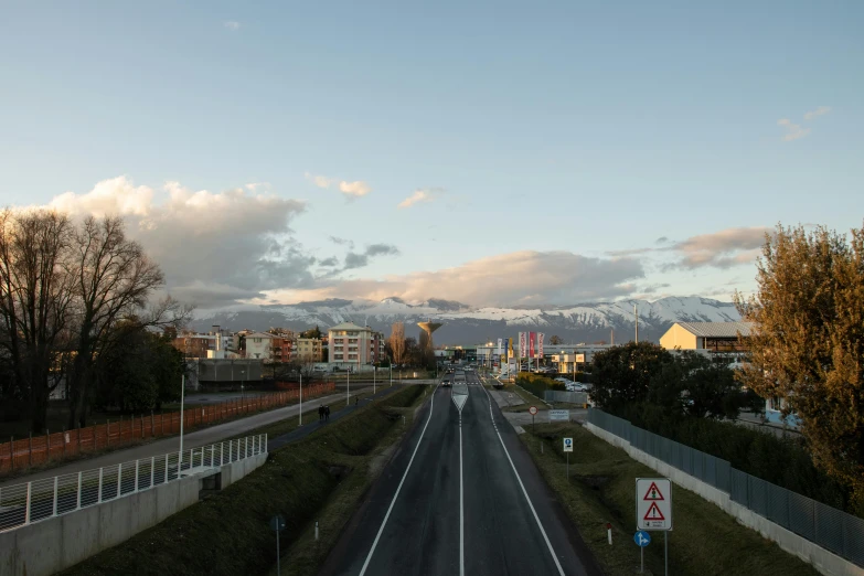 a long highway next to the countryside with houses