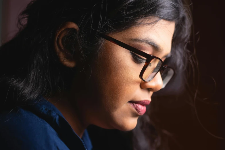 the woman's eyes are in the light, wearing a pair of reading glasses