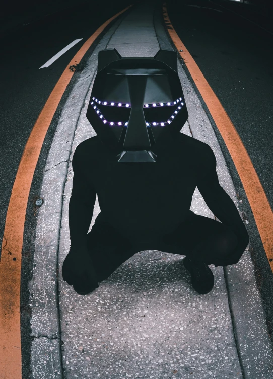 a man kneeling on the side of a train track in a suit