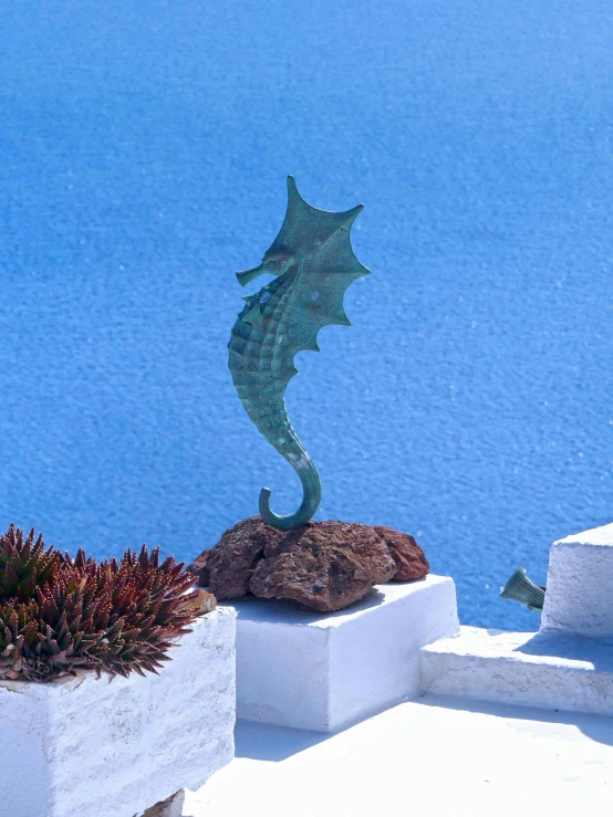 seahorse statue sits in front of the water