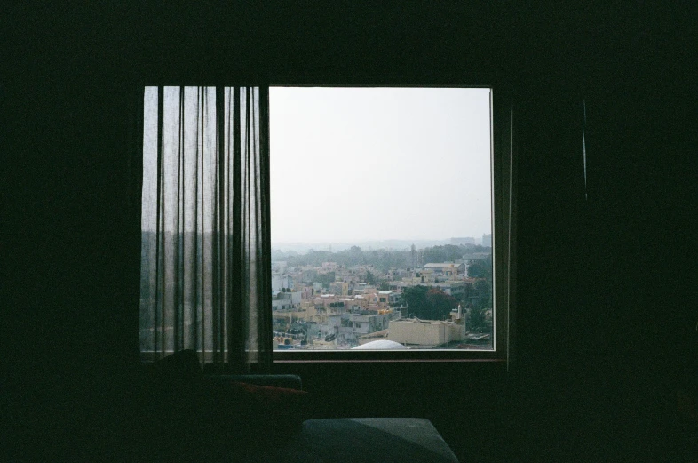 the view from a bedroom window, with rain falling outside