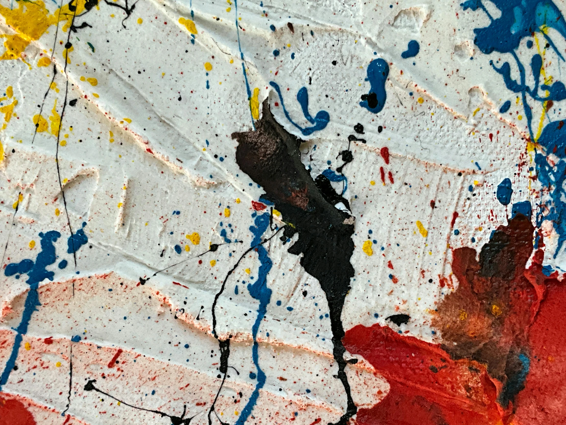 a red and yellow abstract painting with oil splatters