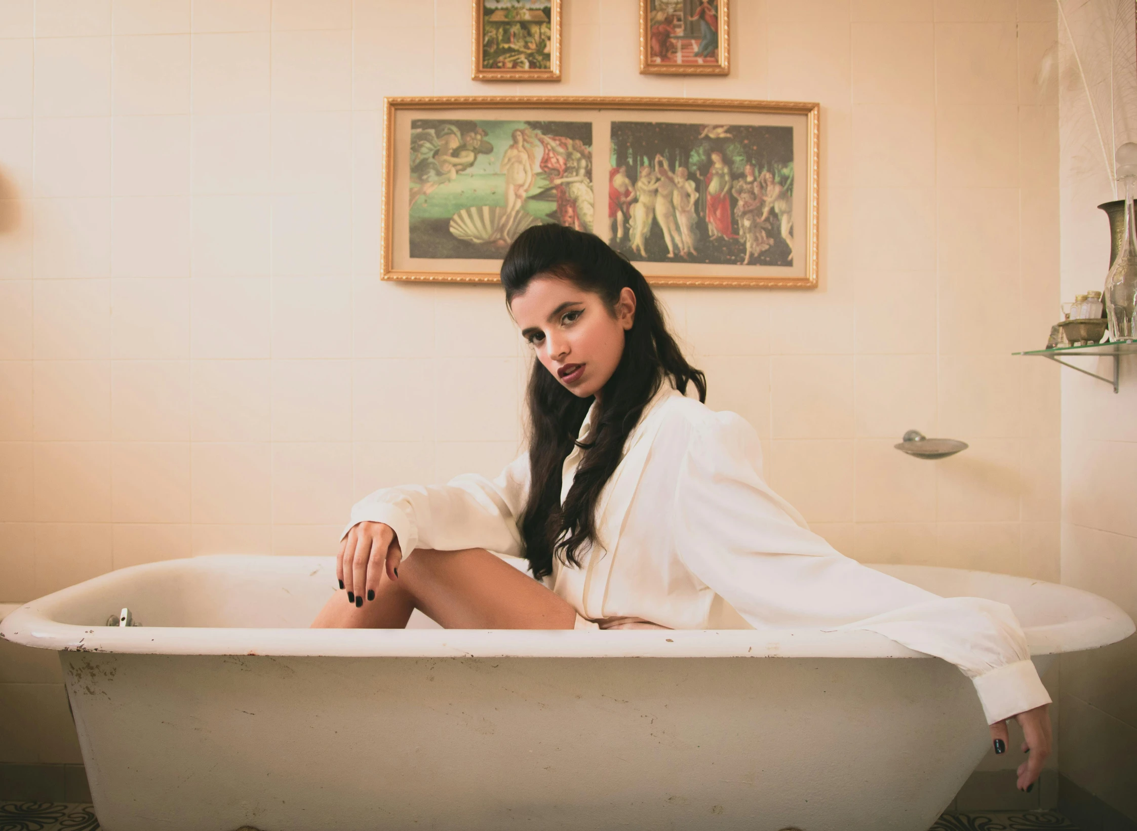 a beautiful young woman sitting in a bathtub posing for the camera