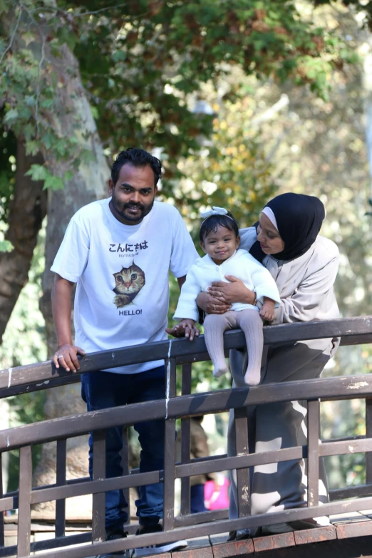 a man, woman and child walking over a bridge