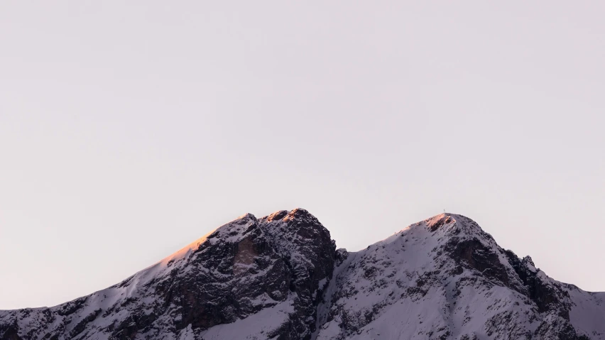 a snow covered mountain range with a yellow peak in the background