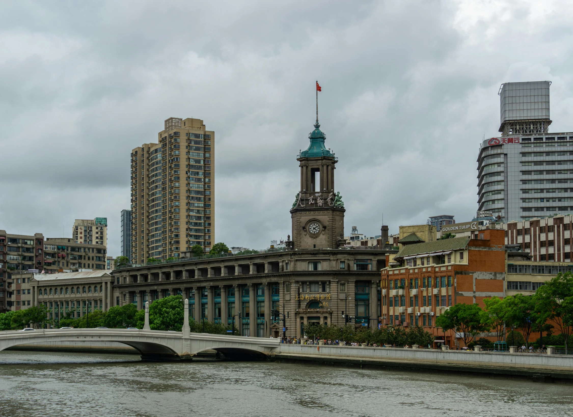 the bridge is near a waterway leading to large buildings