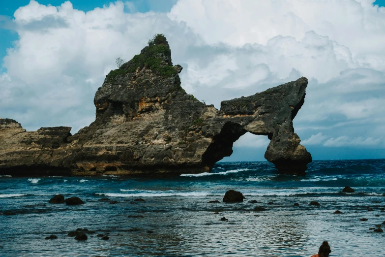 a big rock formation at the ocean beach