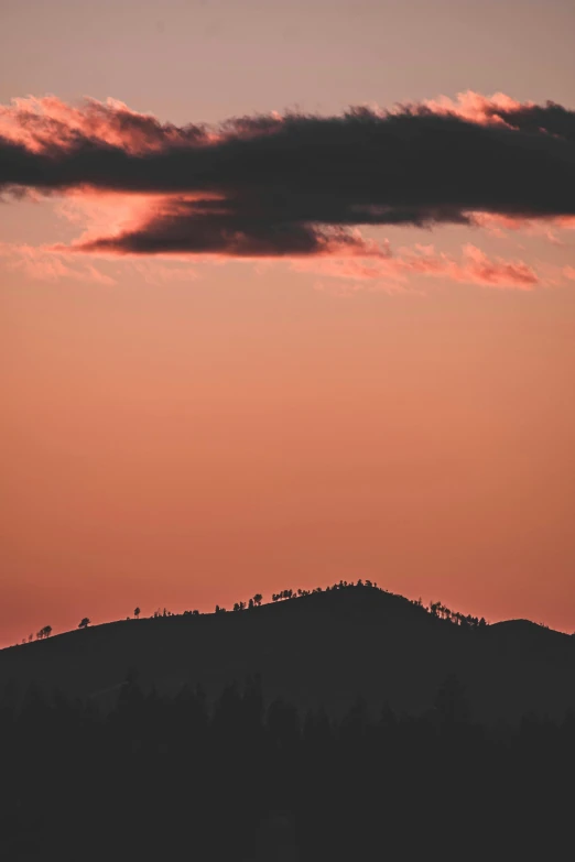 a plane flying over a mountain during sunset