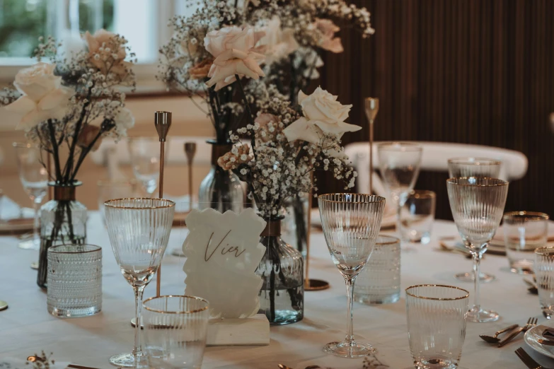 a table with a place card holder and a table with a vase with flowers in it