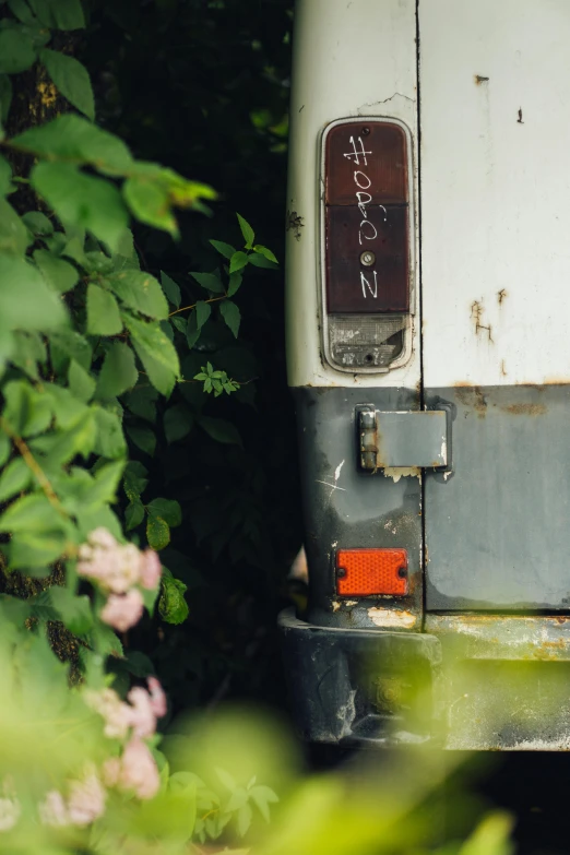 the rear bumper of an old, broken - down bus with graffiti on it