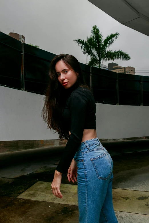 a girl poses while leaning against the side of her car