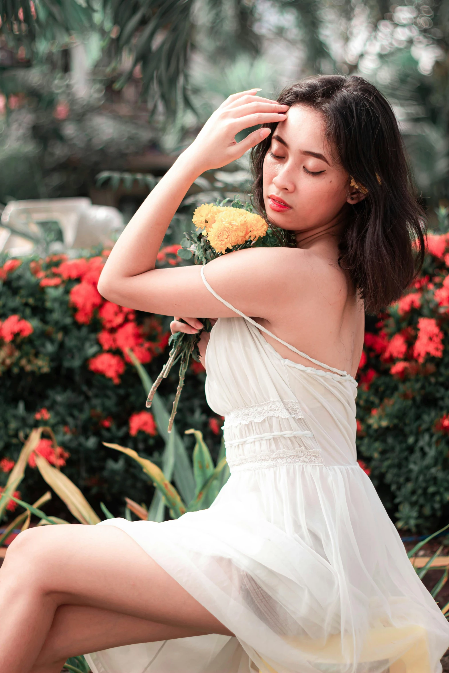 the young woman is wearing a dress holding flowers