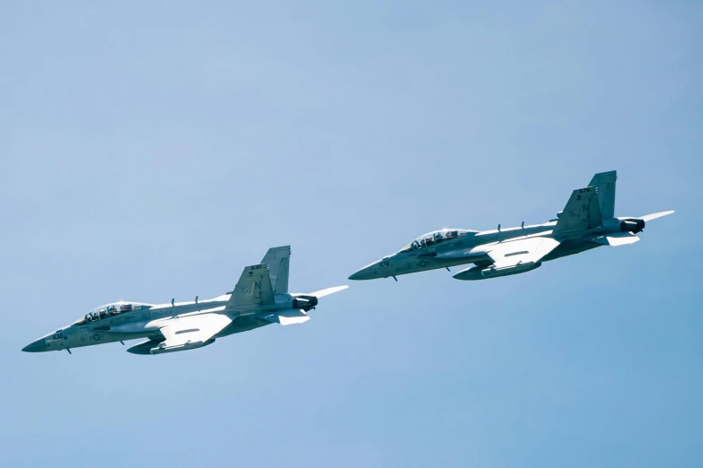 two planes flying side by side in the sky