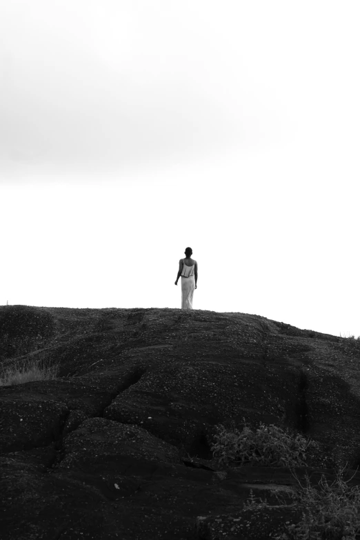 a man walking up a hillside next to a kite