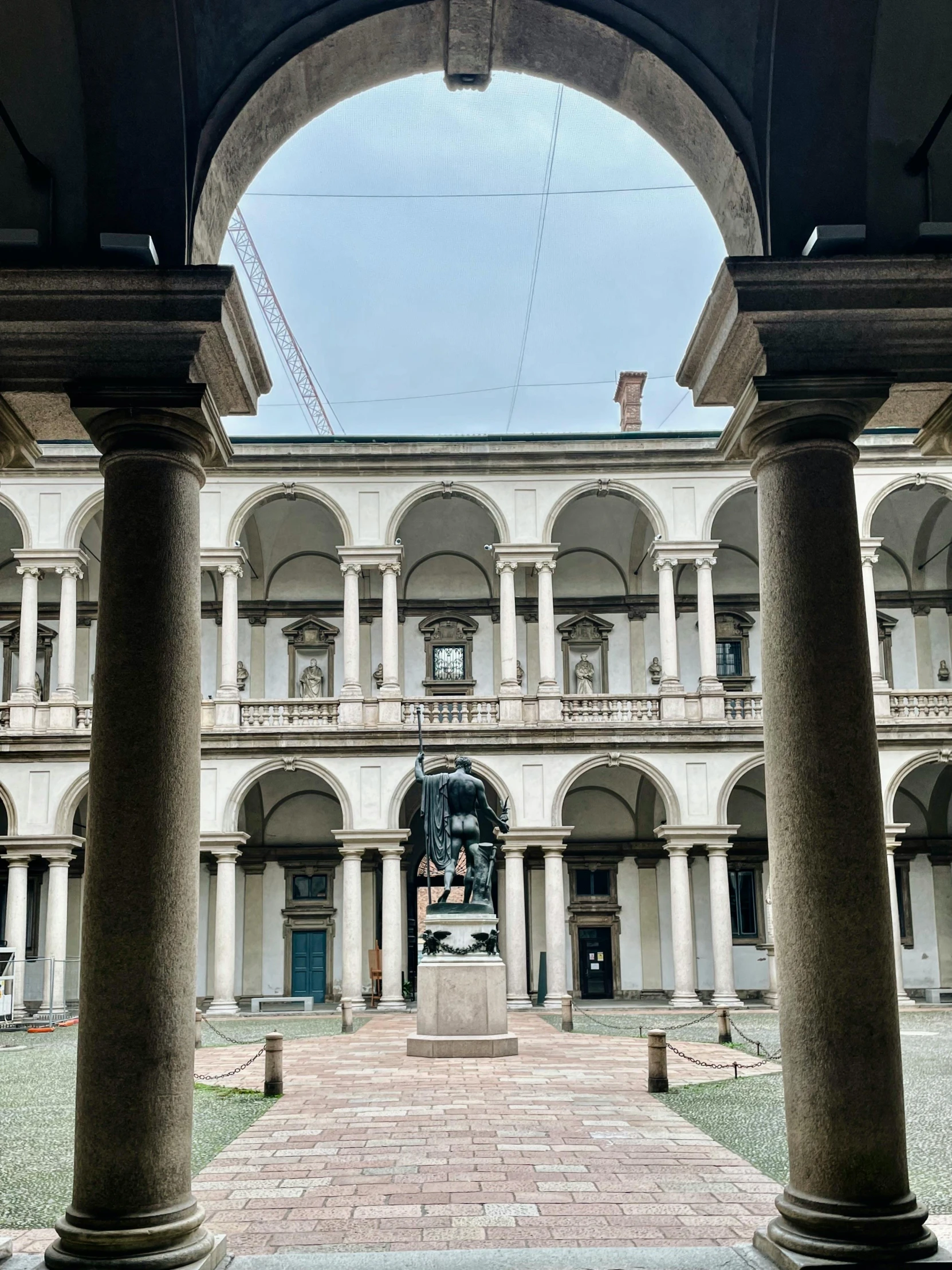 a tall building with several columns and statues inside