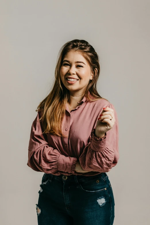 a young woman posing for a picture while standing with her arms folded out