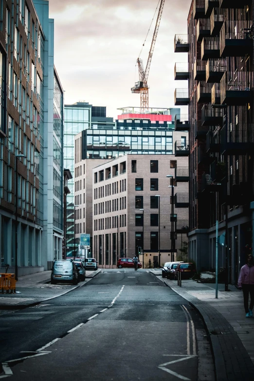 a street with cars, and a person walking on the street