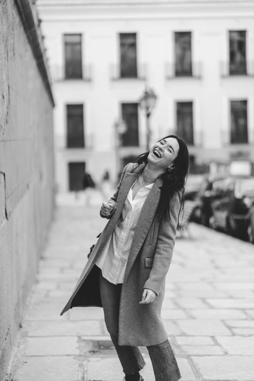 a woman wearing boots and coat standing on sidewalk