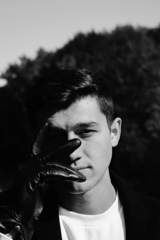 a young man holding up an oven mitt in his hands