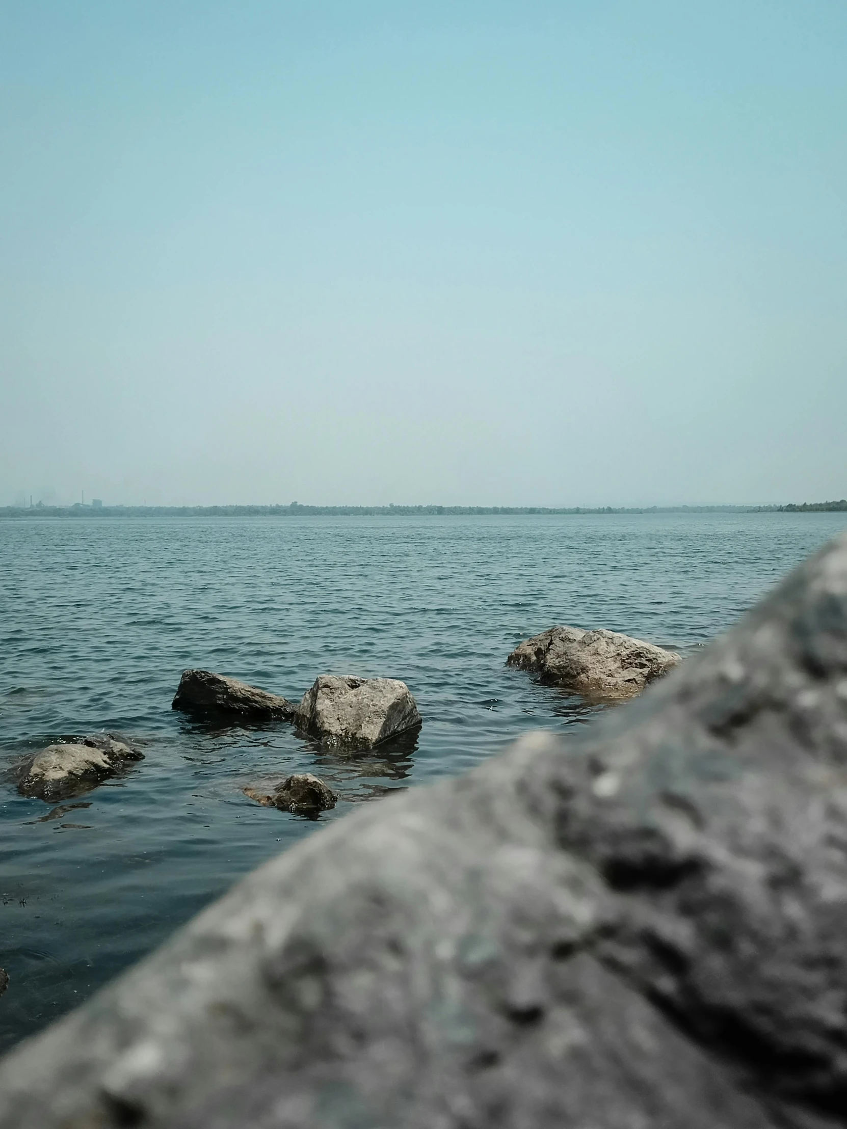 rocks sit on the water near a cliff