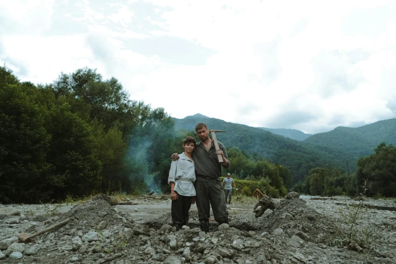 two people standing in front of trees with smoke coming out of them