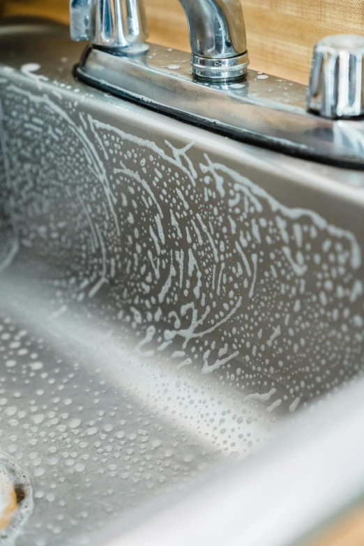 water splashes off the faucet of a kitchen sink