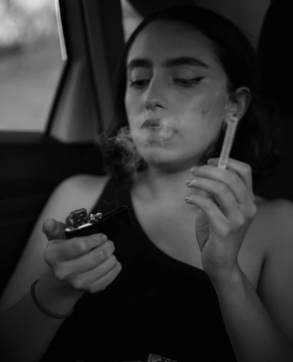 a woman smoking a cigarette and holding her cell phone