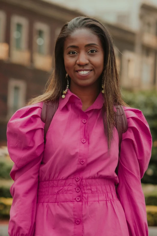 an image of a woman wearing a pink dress and gold earrings