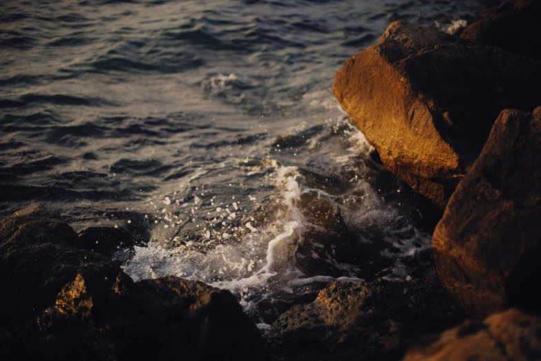 a body of water with waves coming on rocks