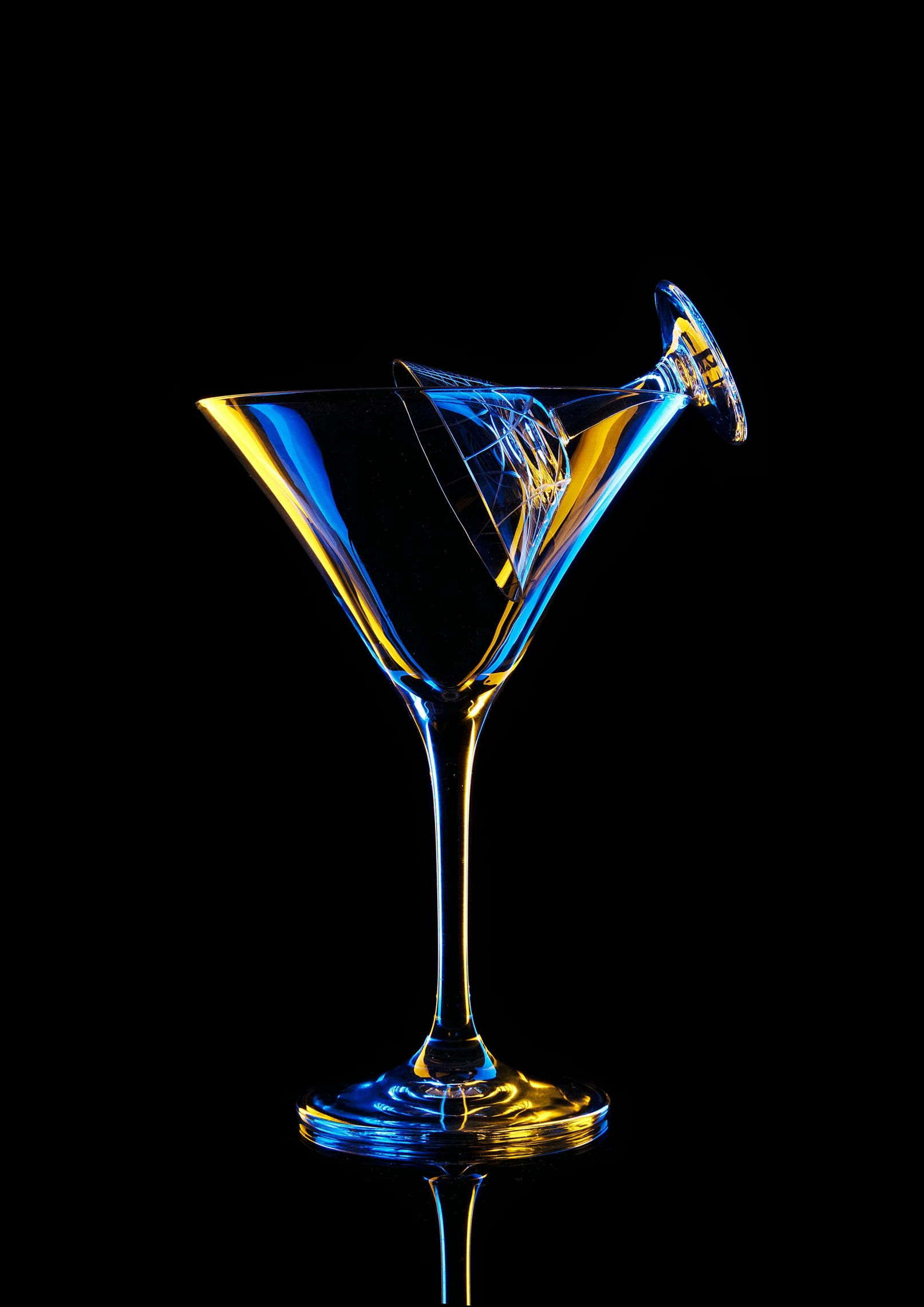 a small martini martini with blue and yellow liquid in the bottom