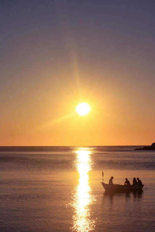 some boats floating in the ocean at sunset