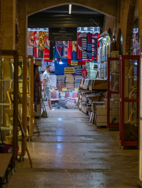 a very narrow store with large shelves and furniture in it