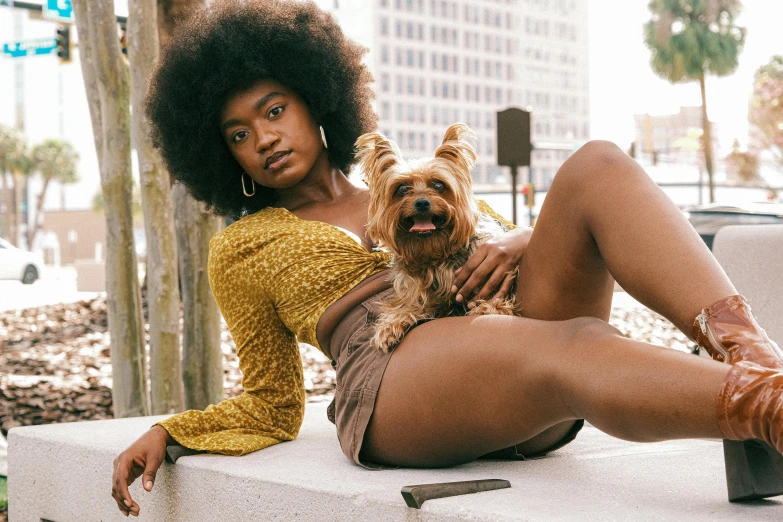 an adorable dog and a beautiful woman are sitting on the curb