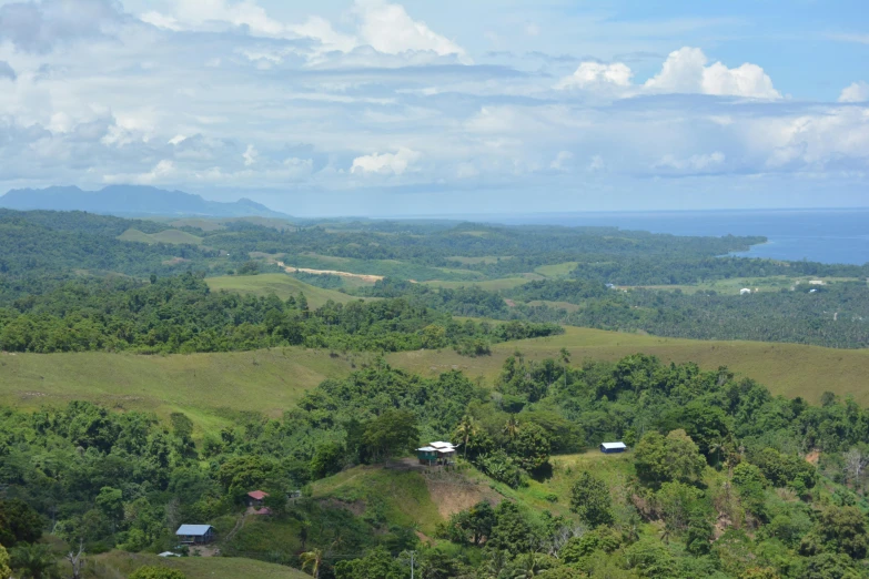 some green hills a small white cabin and a lot of trees