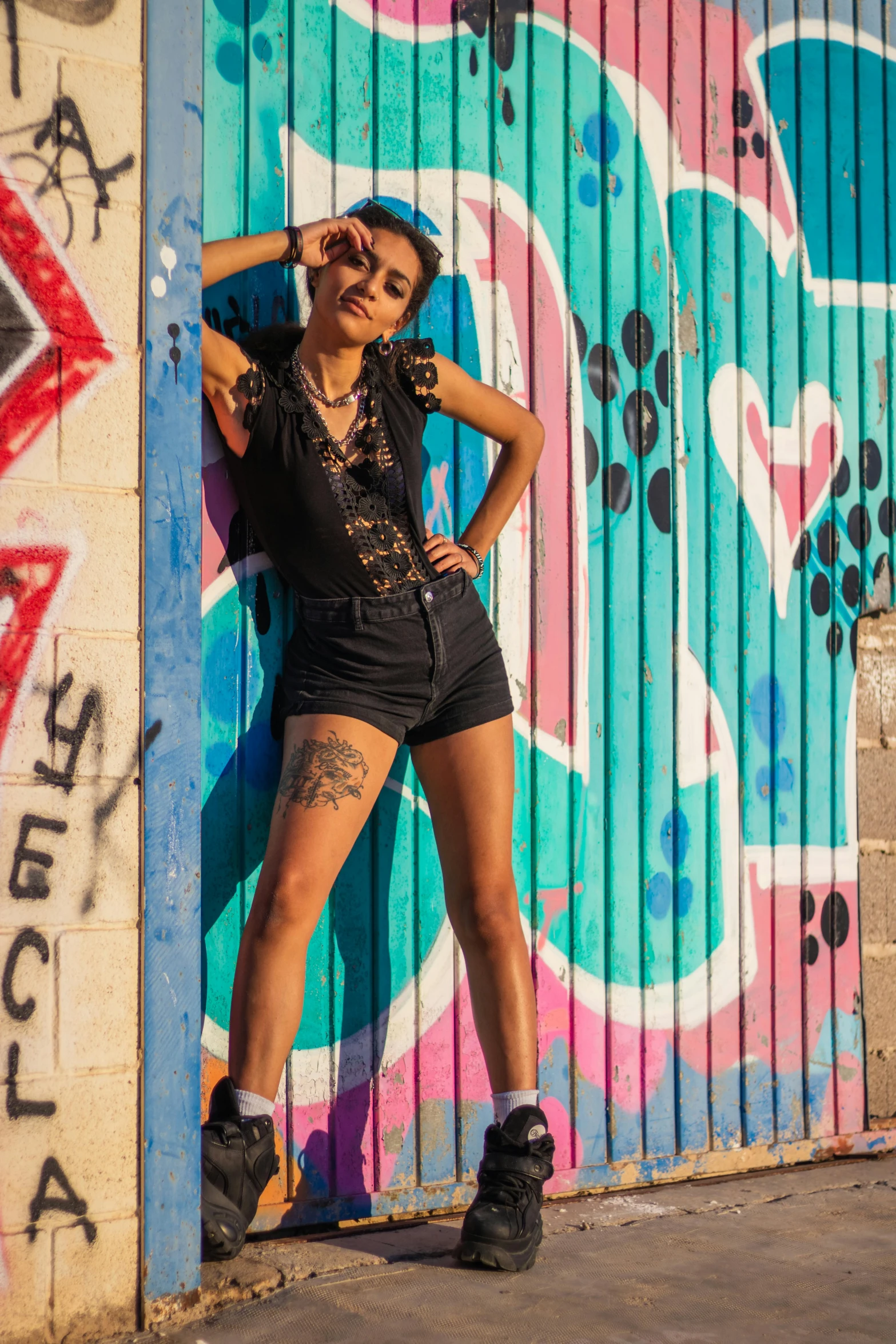 woman leaning on the door with colorful graffiti behind her