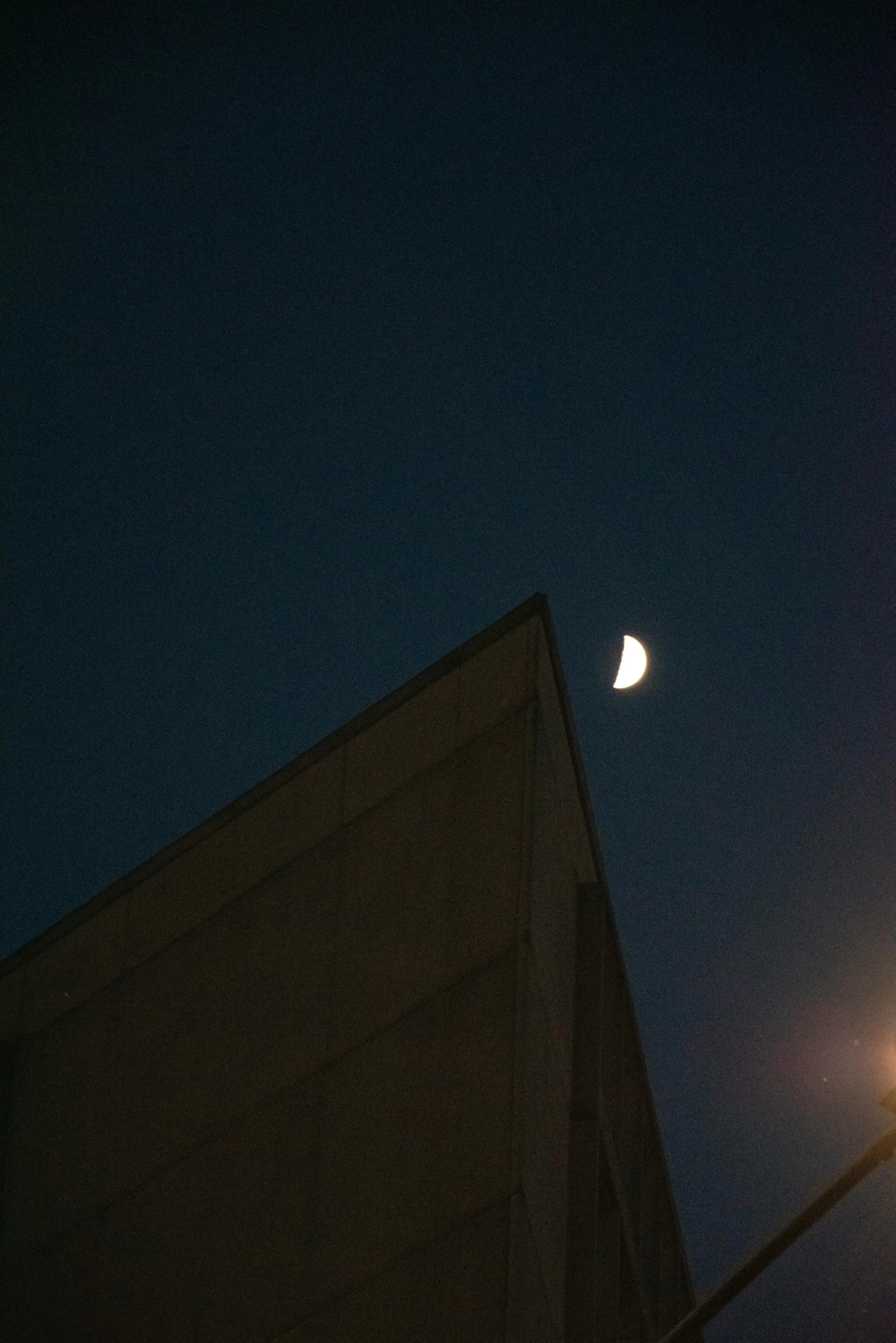 a view looking up at the moon and side of building