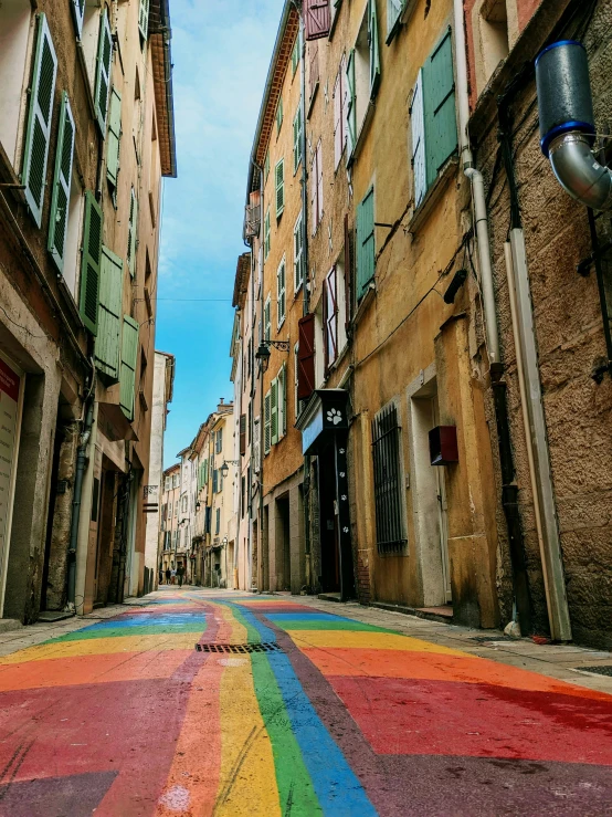 a rainbow colored street with some buildings in the background