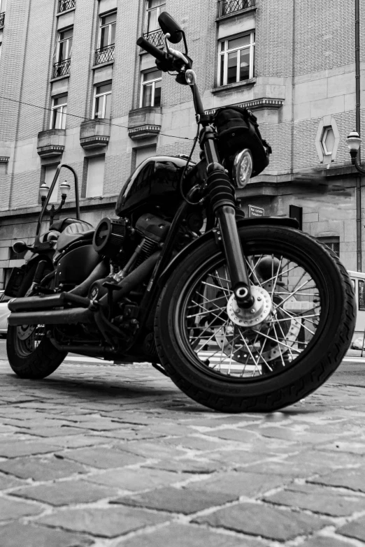 a black motorcycle parked on the side of a brick road