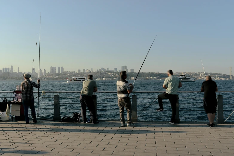 a group of men standing on a pier fishing