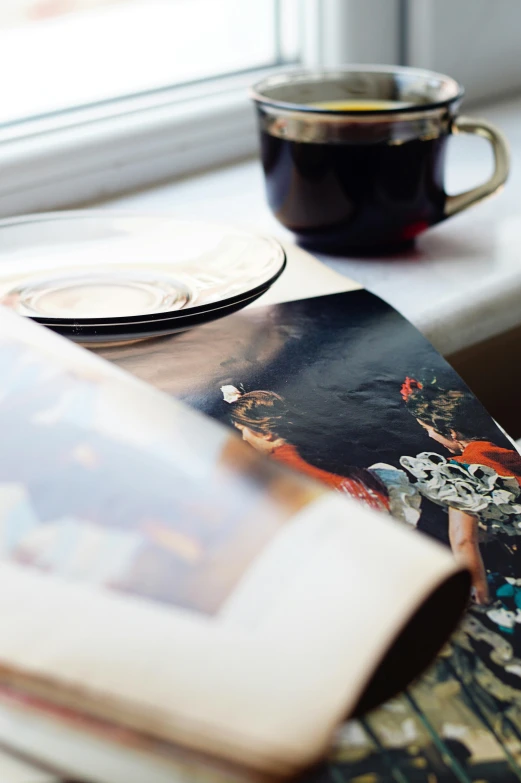 a book, cup and a plate are sitting on a table