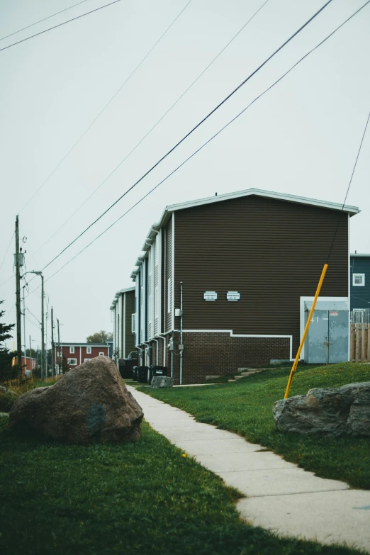 two buildings on an edge of grass near a sidewalk