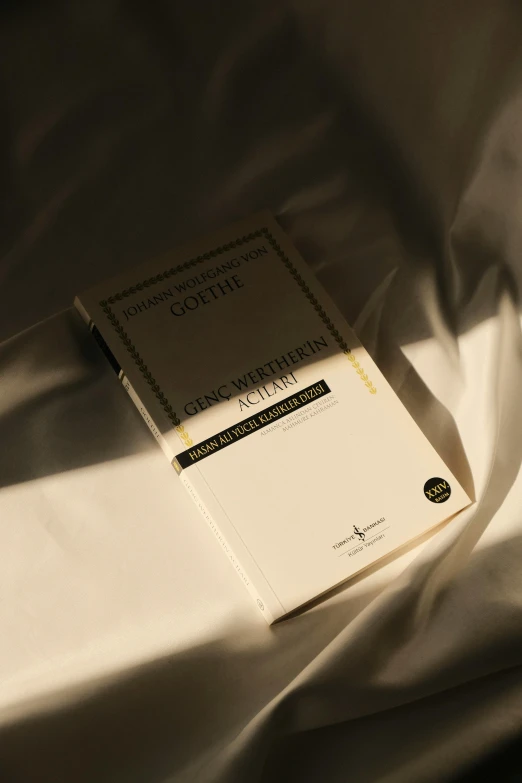 a book is laying on top of some white sheets