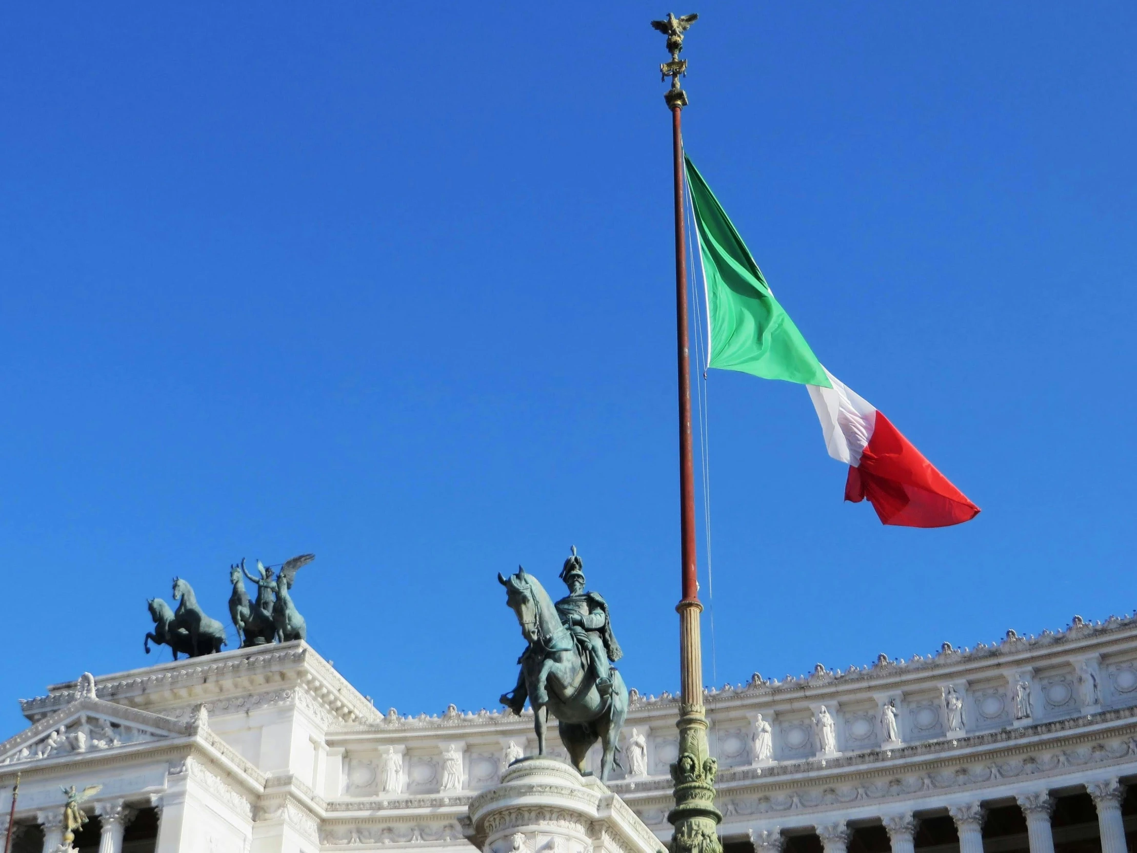 the flagpole and flag atop a statue of a person riding a horse