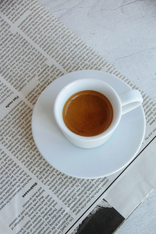 a cup of coffee sitting on top of a white plate