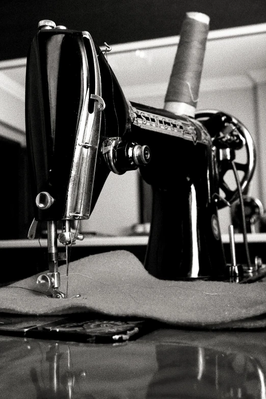 black and white image of a sewing machine on a table