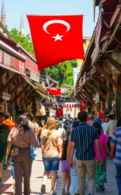 a group of people walking in front of shops on street