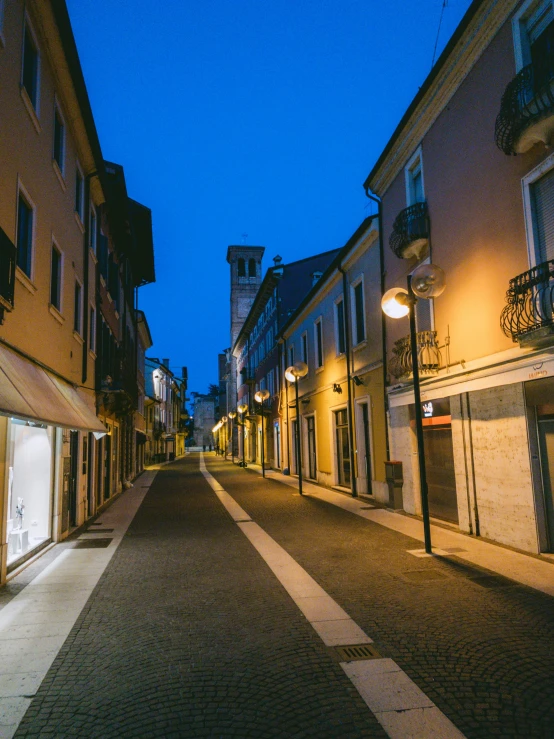 an empty street with a store lit at night